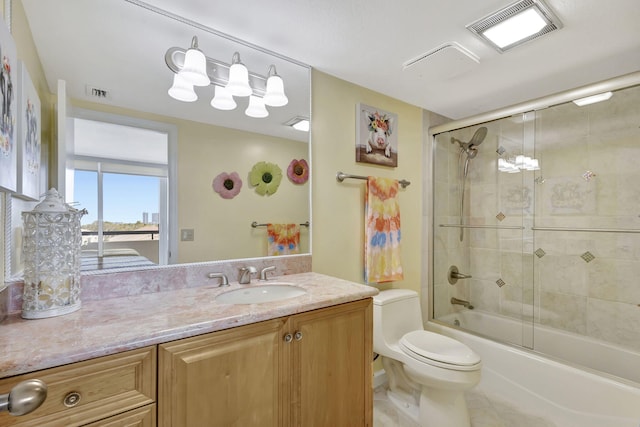 full bathroom with vanity, enclosed tub / shower combo, and toilet