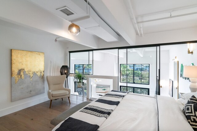 bedroom featuring hardwood / wood-style flooring and beam ceiling