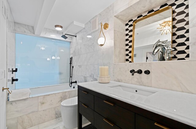 full bathroom with vanity, toilet, tiled shower / bath, and tile walls