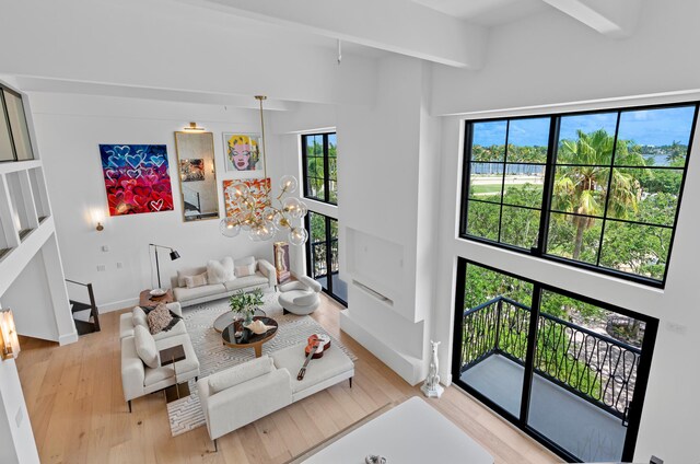 living room featuring a high ceiling, light wood-type flooring, and a wealth of natural light