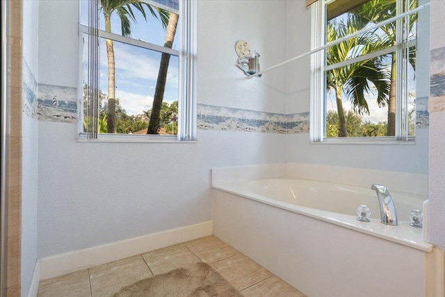 bathroom featuring tile patterned flooring, plenty of natural light, and a bathtub