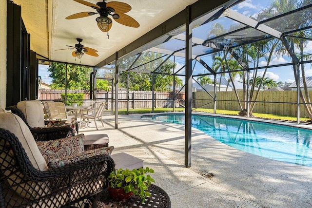 view of pool with glass enclosure, a patio area, and an outdoor hangout area