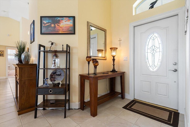 tiled foyer entrance featuring a high ceiling and a healthy amount of sunlight