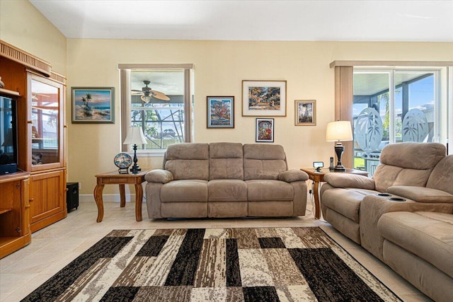 living room with ceiling fan, light tile patterned flooring, and a healthy amount of sunlight