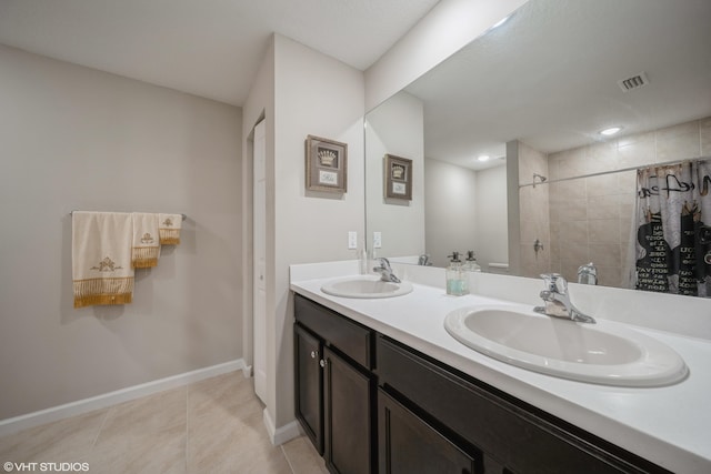 bathroom featuring tile patterned floors, vanity, and a tile shower