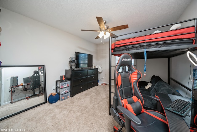 bedroom featuring a textured ceiling, light colored carpet, and ceiling fan