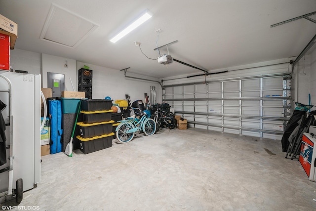 garage featuring white refrigerator, electric panel, and a garage door opener