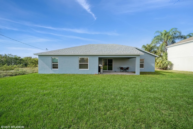 rear view of property featuring a lawn and a patio