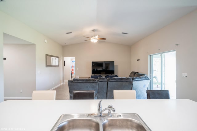 kitchen featuring hardwood / wood-style floors, vaulted ceiling, ceiling fan, and sink