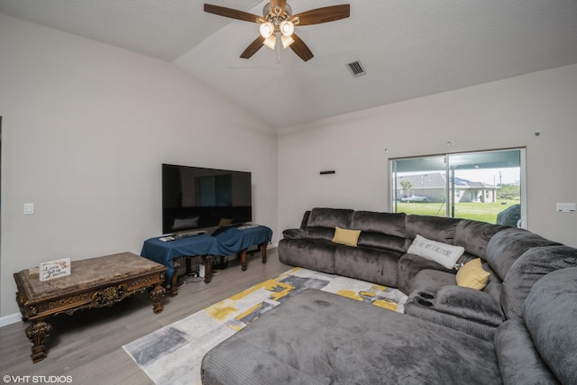 living room featuring ceiling fan, light hardwood / wood-style floors, a textured ceiling, and vaulted ceiling