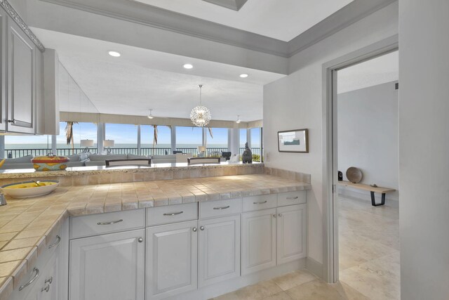 kitchen featuring tile countertops, light tile patterned floors, hanging light fixtures, and an inviting chandelier