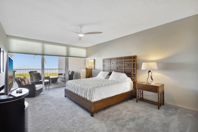 carpeted bedroom with ceiling fan and a textured ceiling