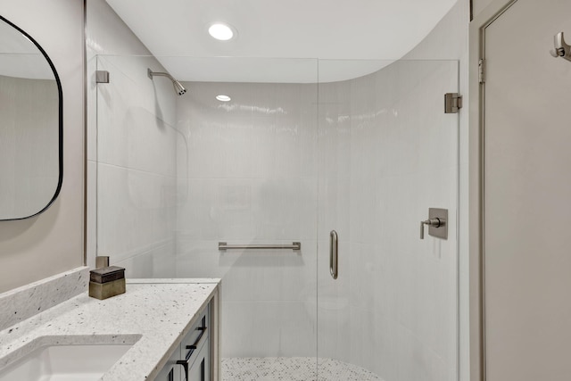 bathroom with a shower with door and vanity