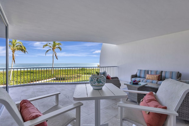 view of patio / terrace with a beach view, a water view, an outdoor hangout area, and a balcony