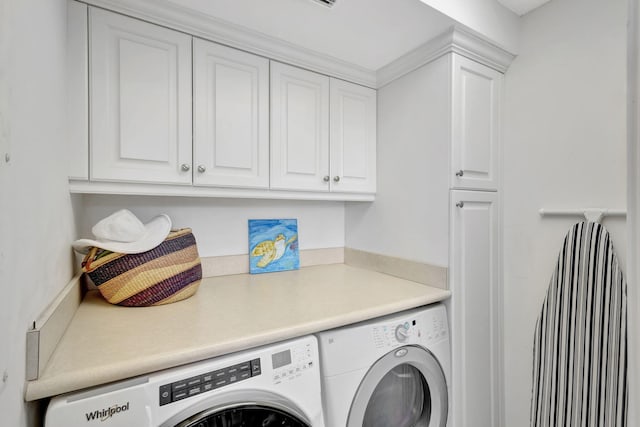 washroom featuring cabinets, washing machine and dryer, and crown molding