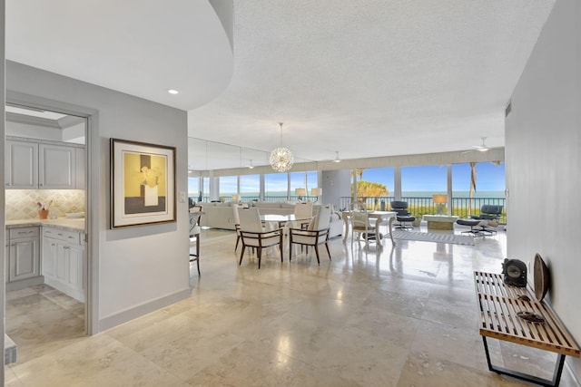 dining space with a textured ceiling and a chandelier