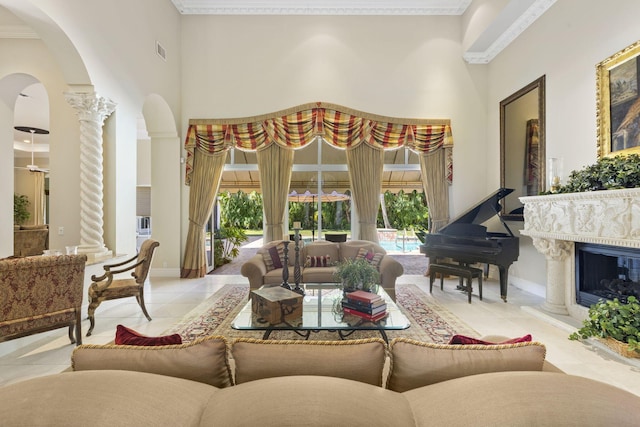 tiled living room with ornate columns, a fireplace, a towering ceiling, and a healthy amount of sunlight