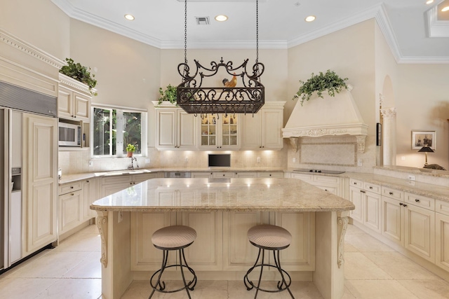 kitchen featuring backsplash, built in appliances, a center island, and a breakfast bar