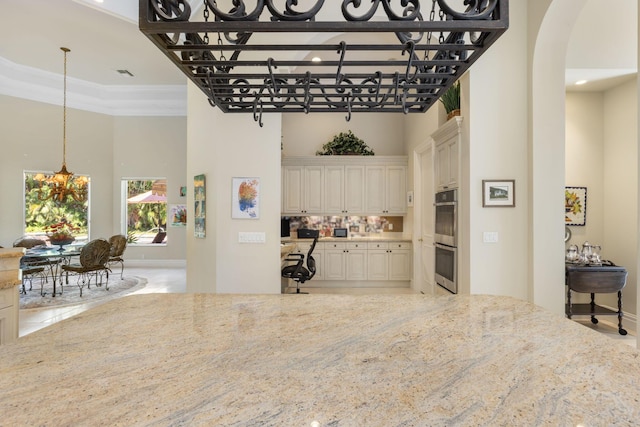 interior space with a raised ceiling, crown molding, and a high ceiling