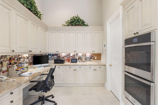 office featuring built in desk and light tile patterned floors