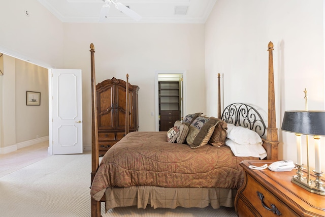 bedroom with ceiling fan, light colored carpet, a walk in closet, and ornamental molding