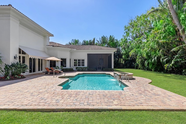 view of pool with a yard, pool water feature, and a patio