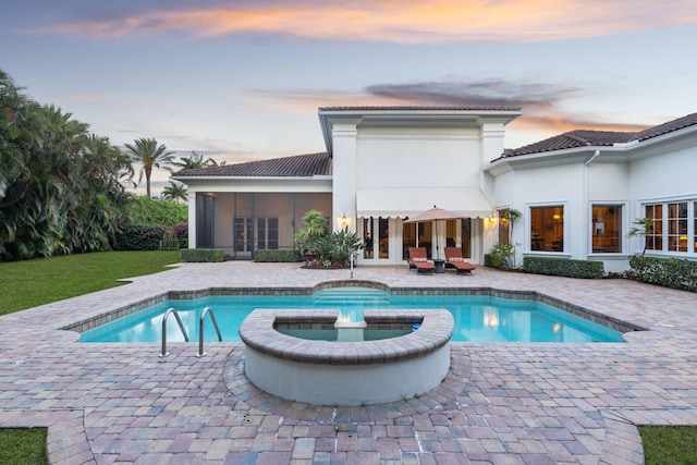 pool at dusk with a sunroom