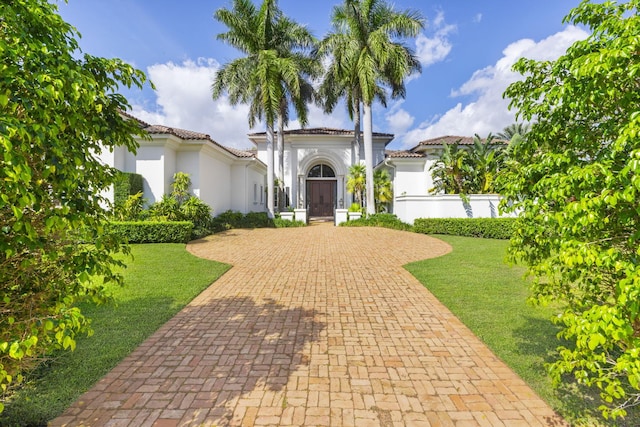 mediterranean / spanish home with a front yard