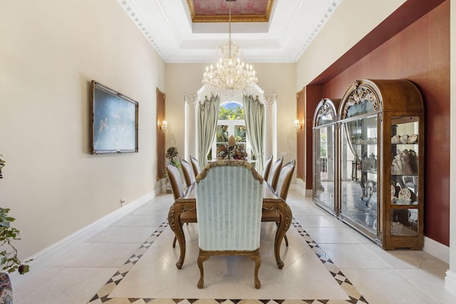 tiled dining space with a notable chandelier, ornamental molding, and a tray ceiling