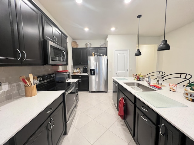 kitchen with sink, stainless steel appliances, backsplash, decorative light fixtures, and light tile patterned flooring