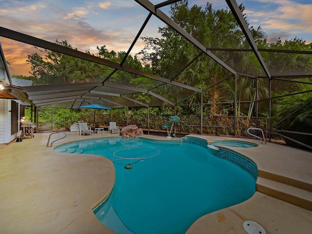 pool at dusk featuring a lanai, an in ground hot tub, and a patio