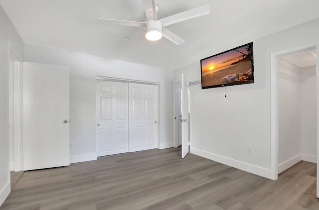 unfurnished bedroom featuring ceiling fan, a closet, and light hardwood / wood-style floors