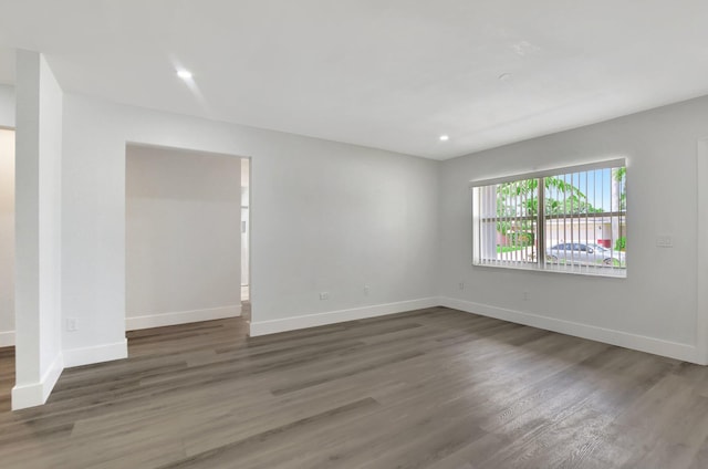 unfurnished room with dark wood-type flooring