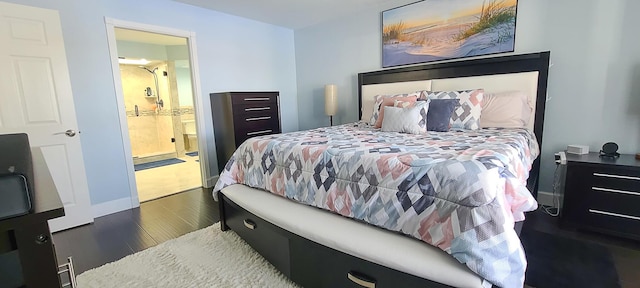 bedroom featuring ensuite bathroom and dark hardwood / wood-style flooring