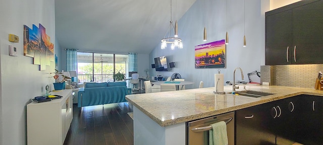 kitchen featuring light stone countertops, dark wood-type flooring, sink, decorative light fixtures, and high vaulted ceiling