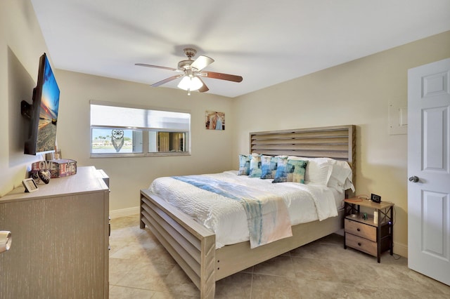 bedroom with light tile patterned floors, a ceiling fan, and baseboards