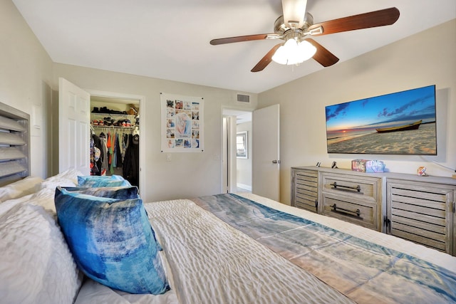 bedroom featuring ceiling fan, visible vents, a walk in closet, and a closet