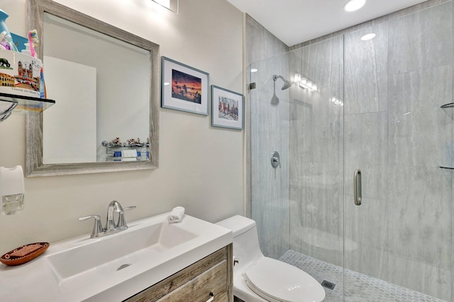 bathroom with a shower stall, toilet, and vanity