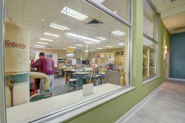 interior space featuring a drop ceiling, visible vents, and baseboards