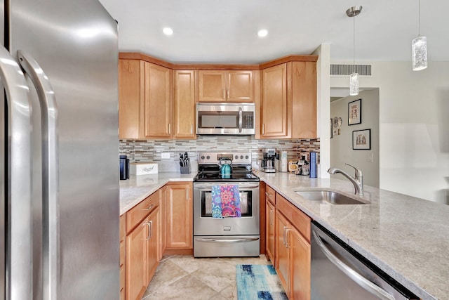 kitchen with stainless steel appliances, visible vents, backsplash, a sink, and light stone countertops