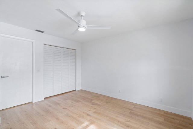 unfurnished bedroom featuring a closet, light hardwood / wood-style flooring, and ceiling fan