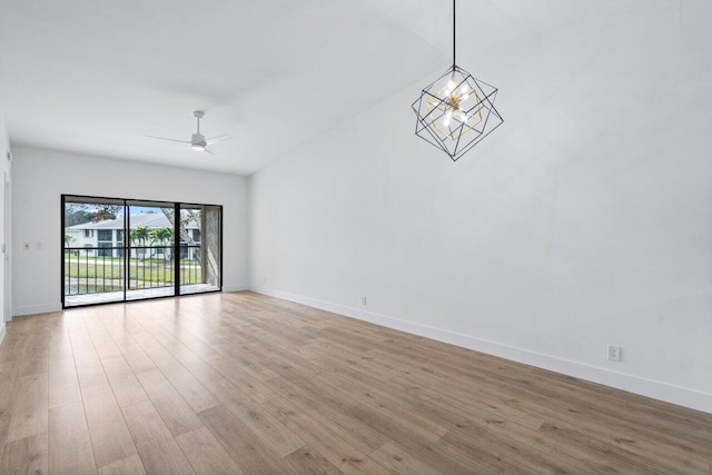 unfurnished room with ceiling fan with notable chandelier and light hardwood / wood-style flooring