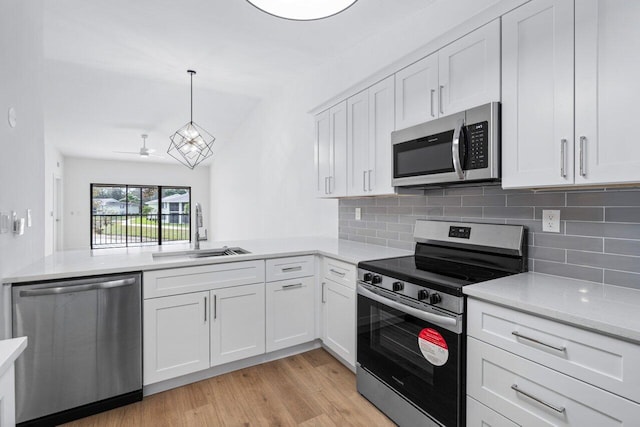 kitchen with tasteful backsplash, white cabinetry, sink, and appliances with stainless steel finishes