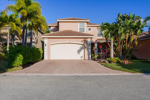 mediterranean / spanish house featuring a garage and a front yard