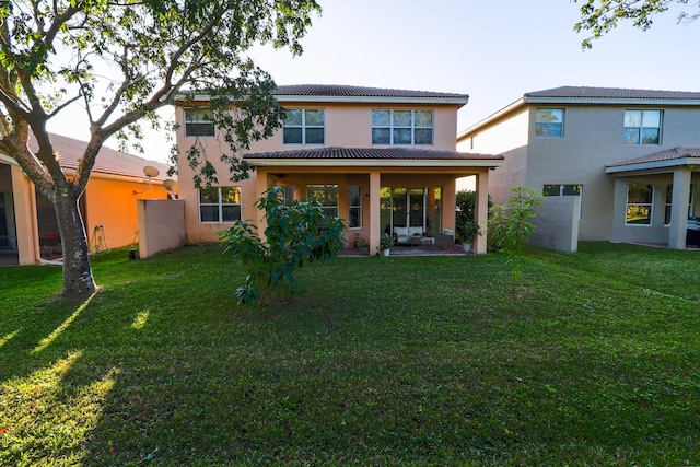 back of house with a yard and a patio