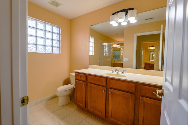 bathroom featuring tile patterned flooring, vanity, toilet, and walk in shower