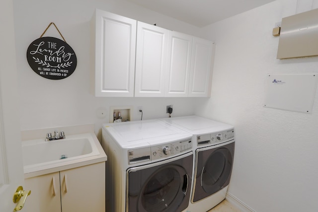 laundry area with cabinets, separate washer and dryer, and sink