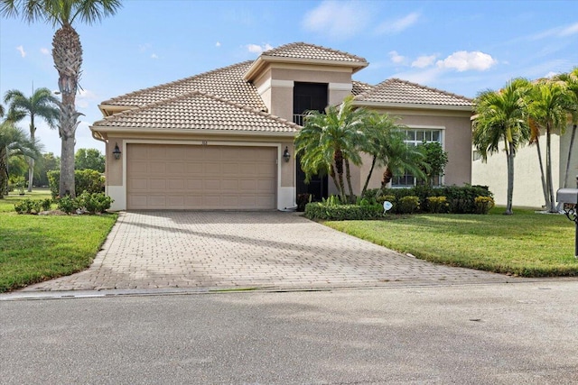 mediterranean / spanish-style home featuring a front yard and a garage