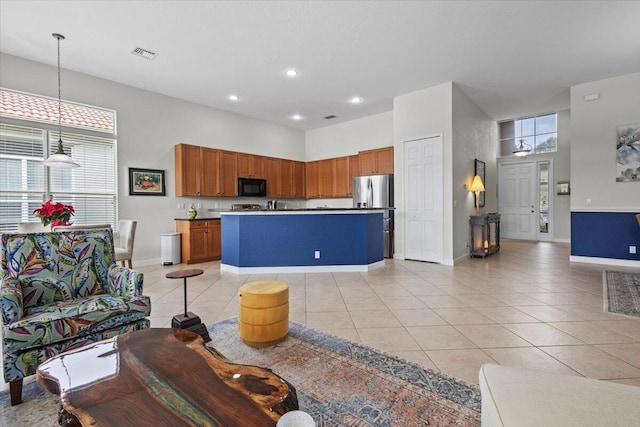 kitchen with pendant lighting, a center island, stainless steel refrigerator, and light tile patterned floors