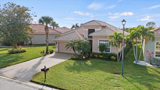 mediterranean / spanish-style home featuring a garage and a front lawn